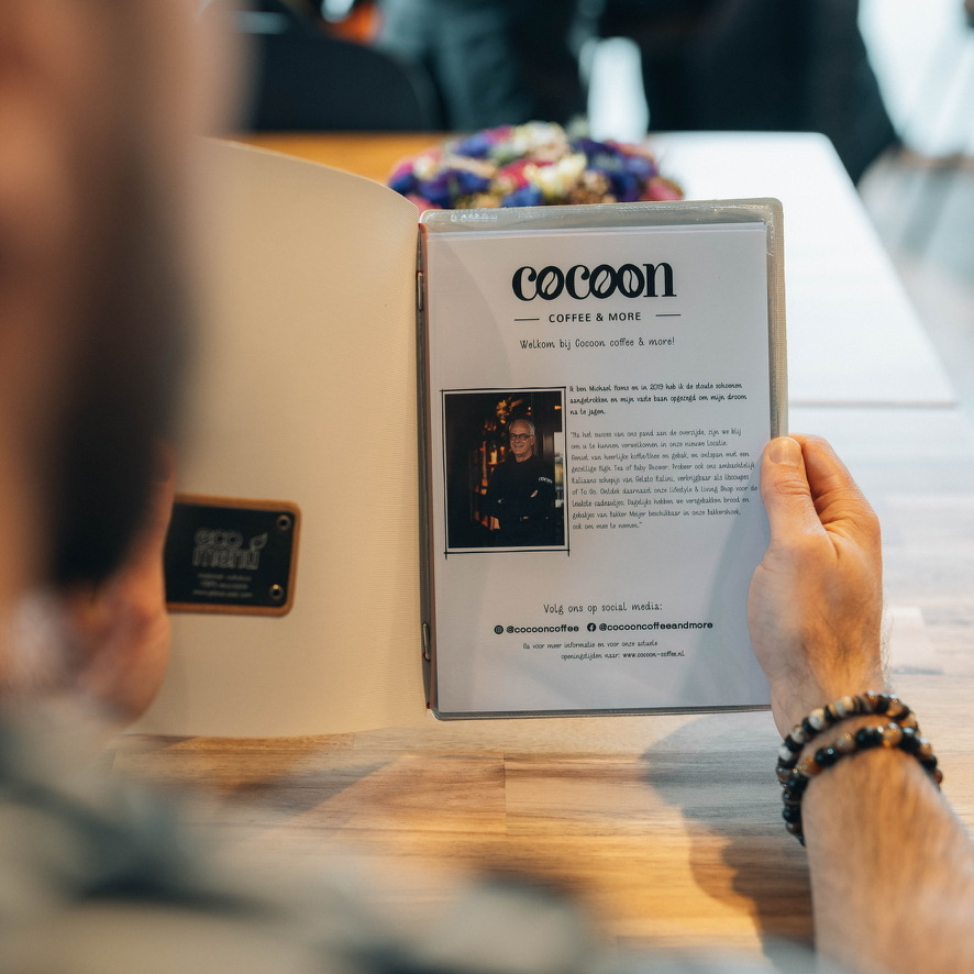 Een gast leest de menukaart van Cocoon coffee & more