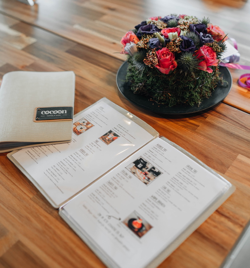 De menukaart van Cocoon coffee & more open op tafel